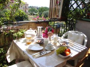LunghezzaにあるCasa Italia Hospitalityの白いテーブル(バルコニーに食べ物と果物付)