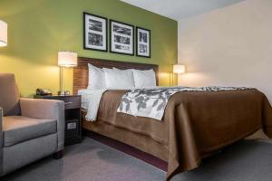 een hotelkamer met een bed en een stoel bij Sleep Inn & Suites Marshall - University Area in Marshall +43 foto's