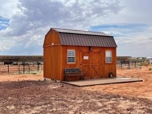 a small wooden building in the middle of a field at Tiny Tiny Bunkhouse in Cane Beds