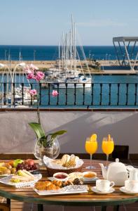 a table with breakfast food and a view of a harbor at La Posada del Mar in Denia
