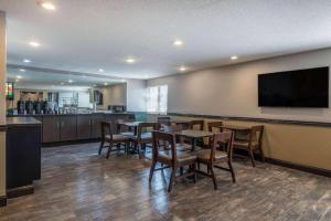a restaurant with tables and chairs and a flat screen tv at Travelodge by Wyndham Brooklyn Center in Minneapolis