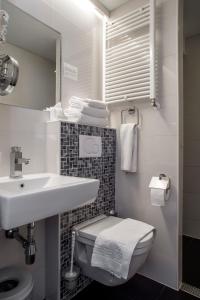 a bathroom with a toilet, sink, and shower at Hotel Larende in Amsterdam