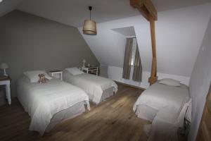 a bedroom with two beds and a teddy bear on the bed at espace détente de rivière in Bettencourt-Rivière