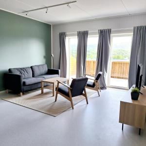 a living room with a couch and chairs at Helt ny sentral 2-roms leilighet i Dyrøy in Brostadbotn