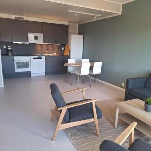 a living room with a couch and a table and chairs at Helt ny sentral 2-roms leilighet i Dyrøy in Brostadbotn