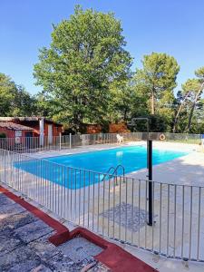 a swimming pool with a fence around it at Au coeur des ocres in Roussillon