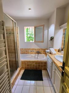 a bathroom with a tub and a sink at Au coeur des ocres in Roussillon
