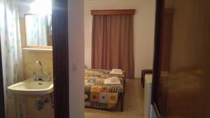 a small bathroom with a bed and a sink at Ipanema Hotel in Tigaki +27 photos
