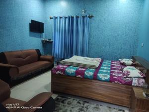 a bedroom with a bed and a couch at Hotel Gauri & Restaurant in Jāmb