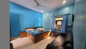 a blue room with a bed and a couch at Hotel Gauri & Restaurant in Jāmb