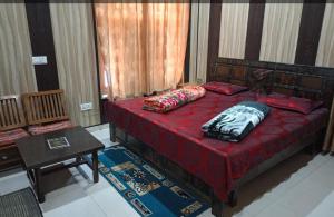 a bedroom with a red bed with pillows on it at Hotel Gauri & Restaurant in Jāmb