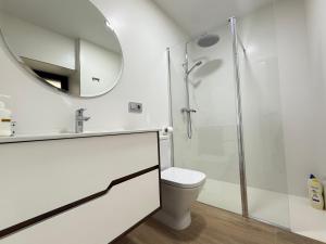 ein weißes Bad mit einem WC und einem Spiegel in der Unterkunft Casa Aldea de Piñeiro, Turismo Rural Padrón by URent in Padrón