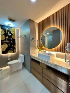 a bathroom with a sink and a toilet and a mirror at Asha suite by Patraland Amarta Apartemen in Kejayan