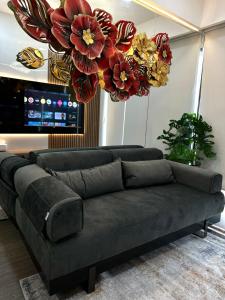 a couch in a living room with flowers on the ceiling at Asha suite by Patraland Amarta Apartemen in Kejayan +13 photos