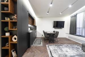 Una sala de estar con una mesa y un televisor. en Victory-30 Luxe Apartment City Center, en Kiev