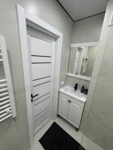 a bathroom with a white door and a sink at Rest & Fly in Chişinău +3 photos