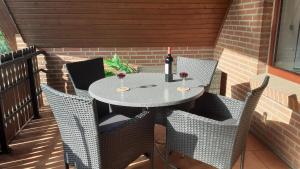 a table with two glasses of wine on a patio at Ferienwohnung Sommerfeld in Bispingen