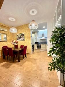 a kitchen and dining room with a table and red chairs at Hispalis San Gonzalo - Triana in Seville