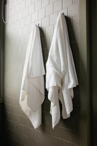 three towels hanging on a wall in a bathroom at Naughtons Hotel in Melbourne +41 photos
