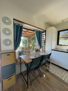 a kitchen with a table and chairs in a room at Le Tahiti Bungalow Surf Lodge in Haapape +3 photos