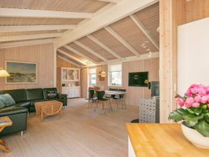a living room with a couch and a table at 6 person holiday home in Strandby in Strandby +18 photos