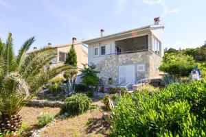 a house with a lot of plants in front of it at Cosy house by the sea in Ist