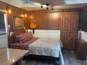 a bedroom with a bed and a guitar on the wall at Something to Write Home about in Cane Beds