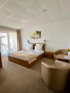 a hotel room with a bed and a chair at Pensiunea Tulip in Baile Felix