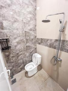 a bathroom with a toilet and a shower at Griya Mahoni Palagan Homestay Jogja in Ngaglik