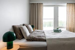 a bedroom with a bed and a large window at Lapin Kansa Suite in Rovaniemi