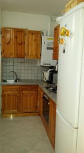 a kitchen with wooden cabinets and a white refrigerator at Il Delfino a Bologna in Bologna