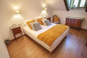 a bedroom with a large bed with yellow blankets and pillows at La vie de château 2 in La Celle-sous-Gouzon