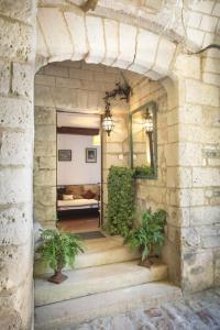 an entrance to a stone building with two potted plants at La vie de château 2 in La Celle-sous-Gouzon