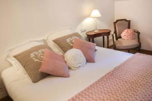 a bedroom with a bed with pillows and a chair at La vie de château 2 in La Celle-sous-Gouzon +1 photo
