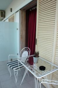 a table and chairs on a balcony with a red curtain at Ψιλή Άμμος in Tolo