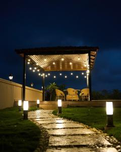 un pabellón con luces, mesa y sillas en Miraya Villa, en Malavli