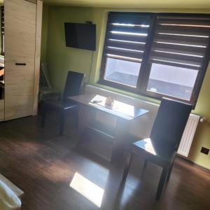 a dining room with a table and chairs and a window at CASA Maria in Orlat