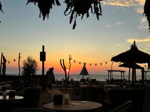 a sunset at the beach with tables and chairs at Tiny House - Surfers Paradise in Noordwijk