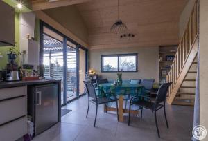 a kitchen and dining room with a table and chairs at La joline, maison bioclimatique in Montastruc-de-Salies
