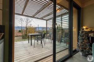 a screened in porch with a table and chairs at La joline, maison bioclimatique in Montastruc-de-Salies