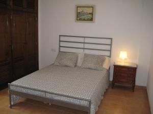 a bedroom with a bed and a night stand with a lamp at Mirador del Roque in Órzola