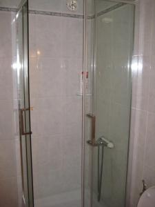 La salle de bains est pourvue d'une douche avec une porte en verre. dans l'établissement Mirador del Roque, à Orzola