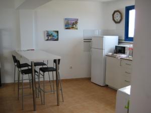 a kitchen with a table and chairs and a refrigerator at Mirador del Roque in Órzola