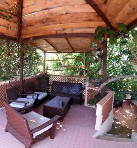 a patio with benches and tables and a wooden pergola at B&B Casa Derosas in Golfo Aranci