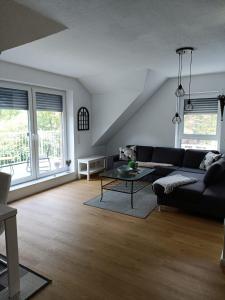 un soggiorno con un divano nero e un tavolo di Ferienwohnung1 Monteurwohnung Nordsee ad Aurich