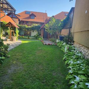 a yard of a house with green grass and buildings at CASA Maria in Orlat