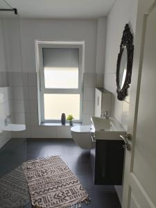 un bagno con lavandino, WC e finestra di Ferienwohnung1 Monteurwohnung Nordsee ad Aurich Altre 7 foto