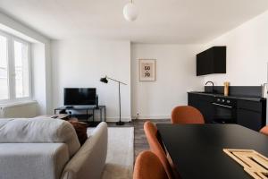 a living room with a couch and a table at Le Joubert in Valence