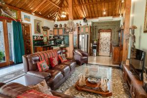a living room with a leather couch and a table at Villa Joglo Ayu in Uluwatu