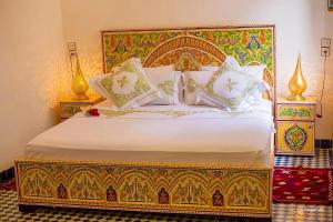 a bedroom with a bed with a gold and white bedspread at Riad Rayhana-Exclusive Riad Experience in Fes Medina in Fès